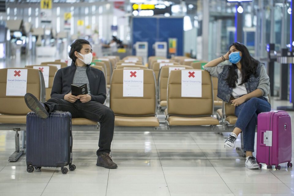 two passengers during covid 19 social distancing and wearing masks in order to support safety in the aviation industry